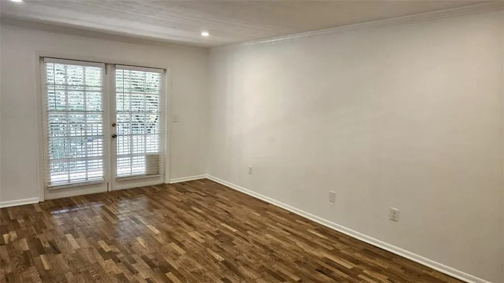Unfurnished room featuring dark wood finished floors, crown molding, and recessed lighting