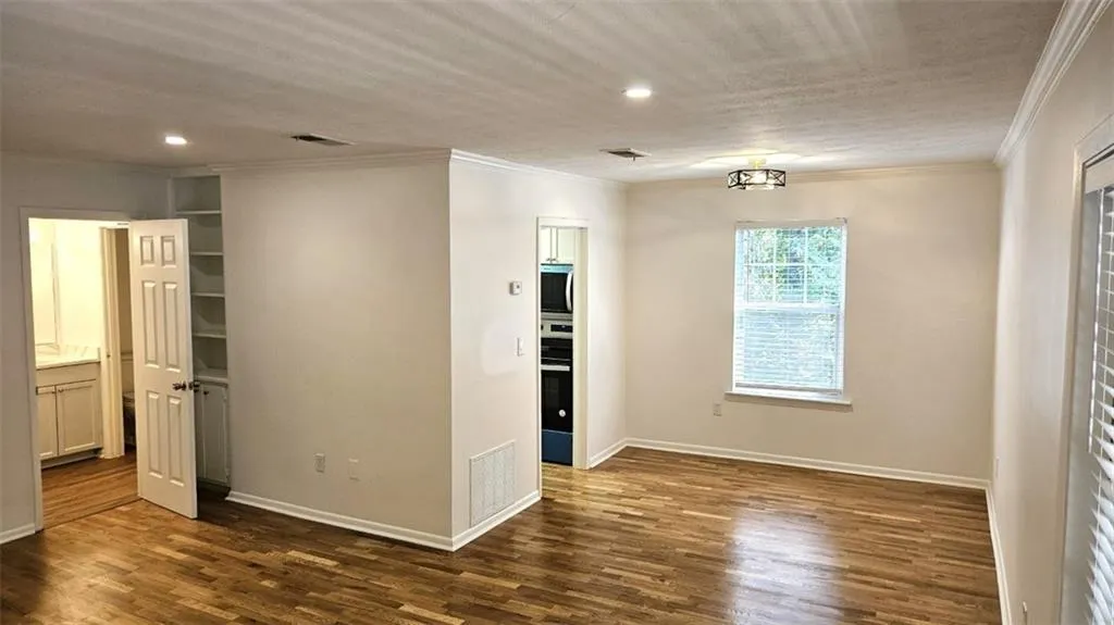 Unfurnished bedroom featuring ornamental molding, dark wood-type flooring, and recessed lighting