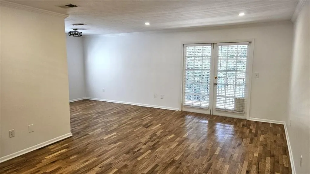 Unfurnished room featuring ornamental molding, dark wood-type flooring, and recessed lighting
