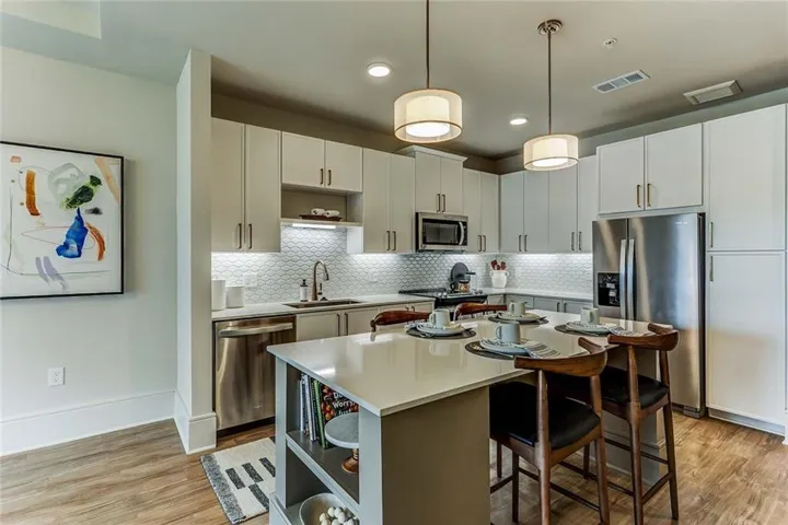 Kitchen with a kitchen island, a sink, stainless steel appliances, and open shelves