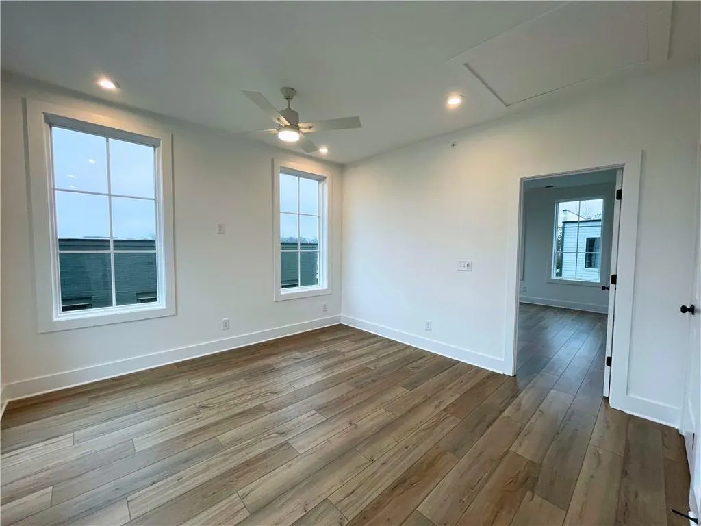 Empty room with a ceiling fan, recessed lighting, and dark wood-style flooring