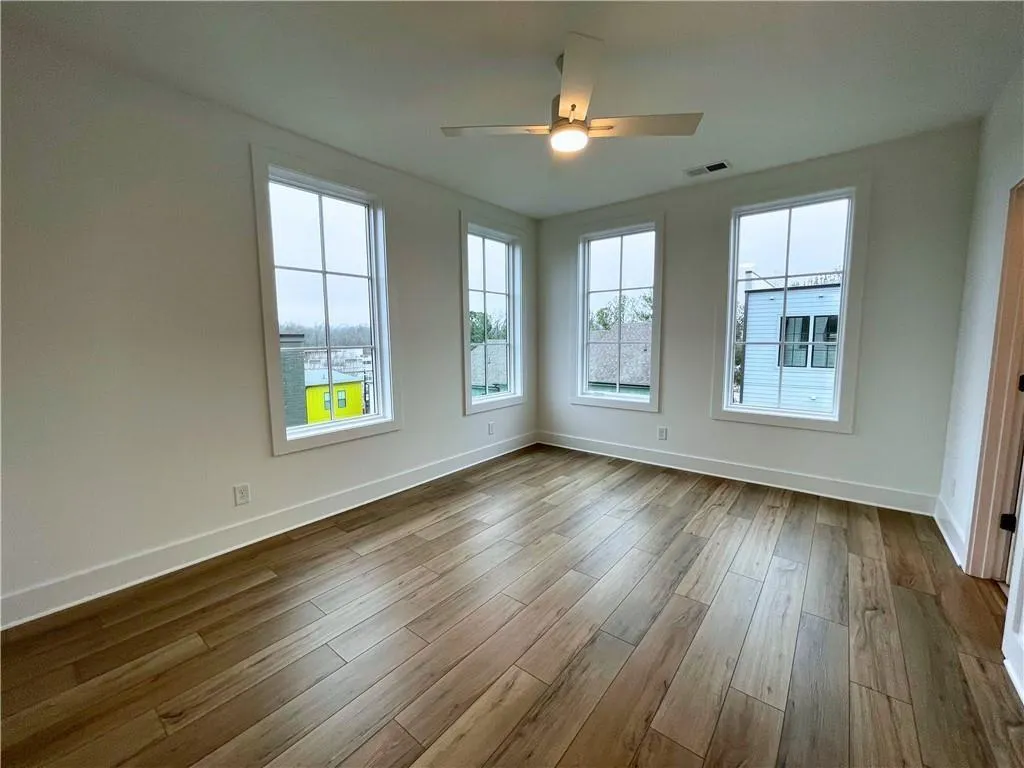 Unfurnished room with ceiling fan and dark wood-type flooring