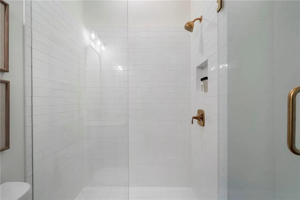 Bathroom with a shower stall and toilet