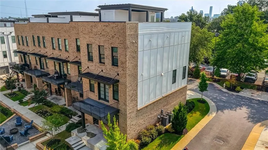 Modern townhome exterior featuring light-brown brick and vertical white siding
