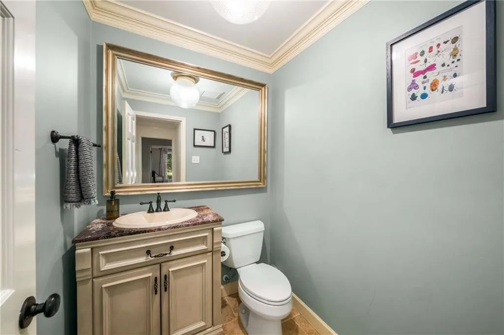 Half bathroom featuring crown molding and vanity