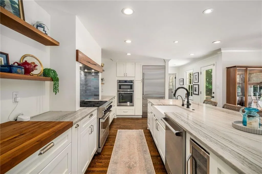 Kitchen featuring open shelves, premium appliances, recessed lighting, dark wood-type flooring, and light stone counters
