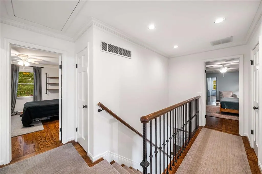 Hall featuring an upstairs landing, wood finished floors, recessed lighting, crown molding, and attic access