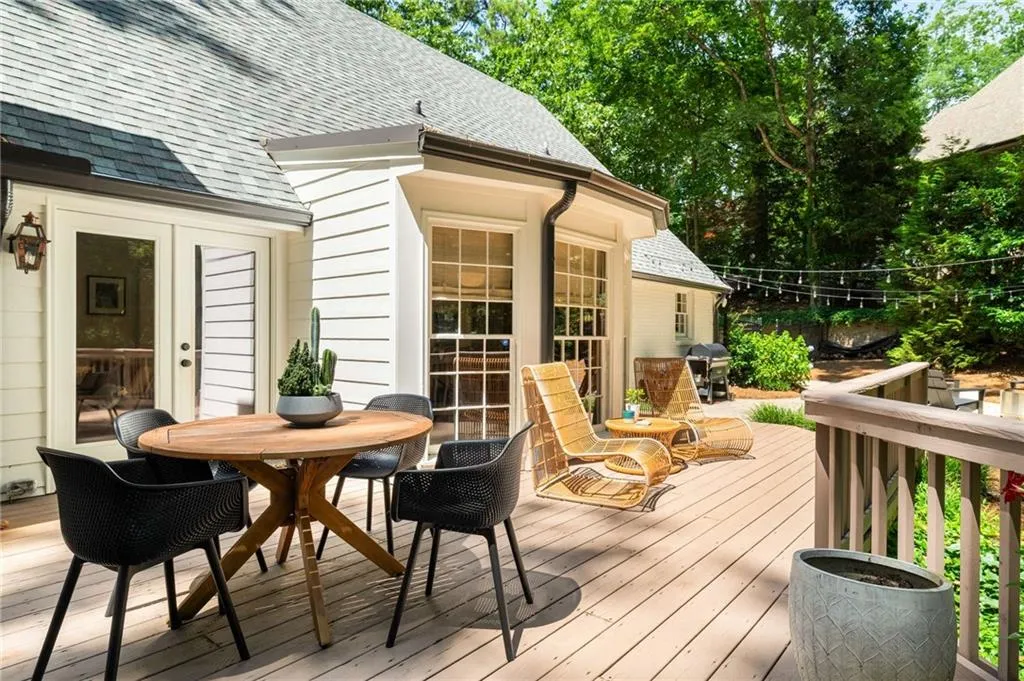 Wooden terrace featuring a grill and outdoor dining space