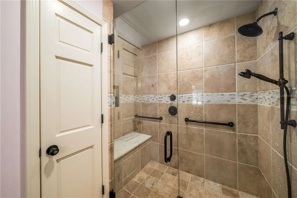 Full bath with a stall shower and ornamental molding