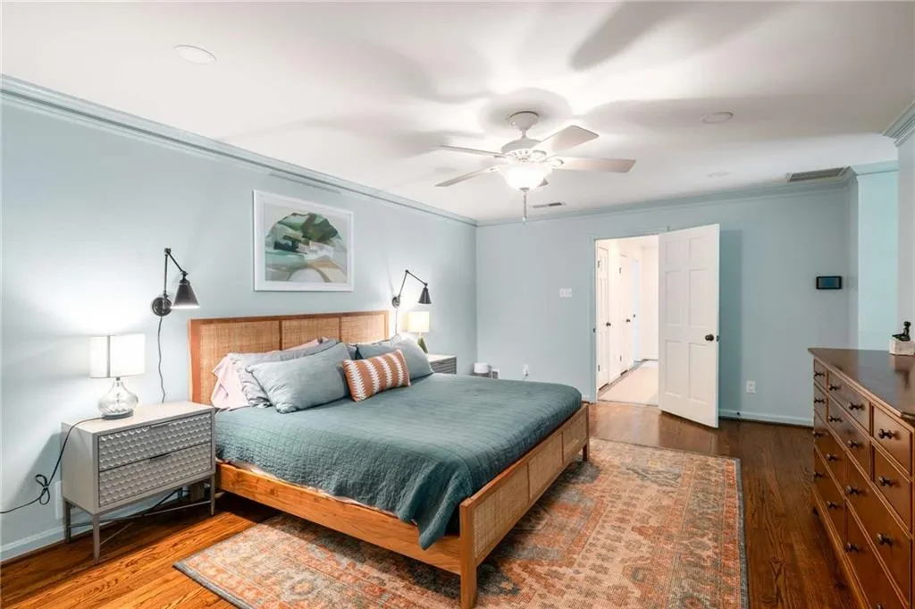 Bedroom featuring crown molding, wood finished floors, and ceiling fan