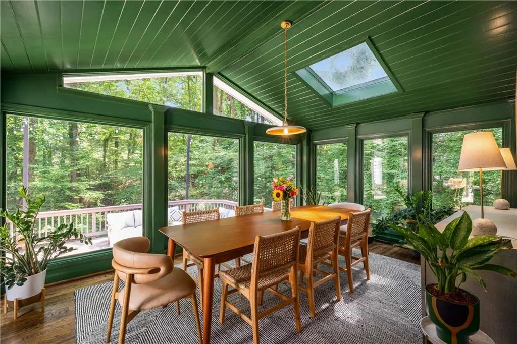 Sunroom/dining  featuring a skylight, wood finished floors, and lofted ceiling