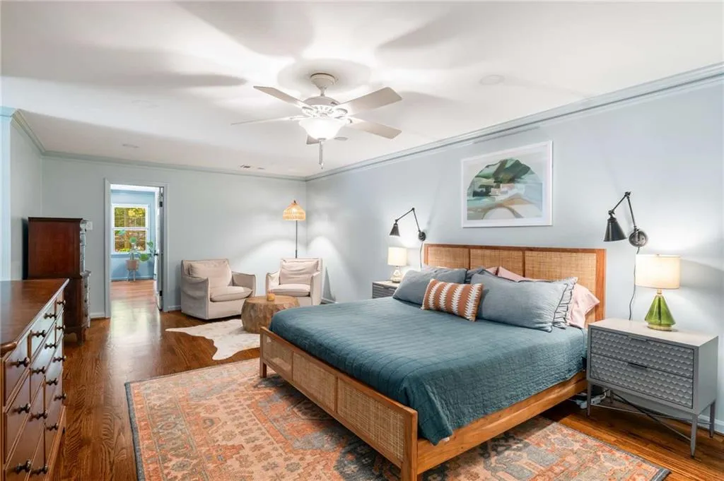 Bedroom with crown molding, wood finished floors, and ceiling fan