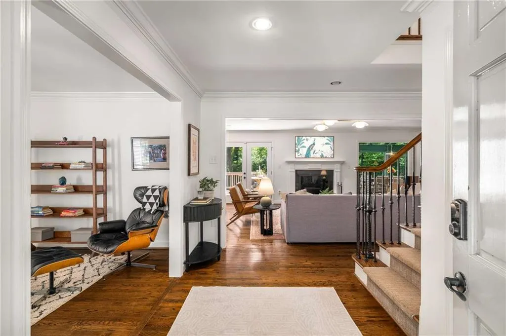Entryway featuring stairs, ornamental molding, dark wood-style flooring, a fireplace, and recessed lighting