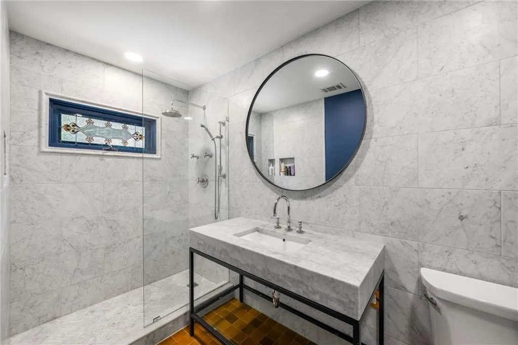 Full bathroom featuring walk in shower, tile walls, and vanity