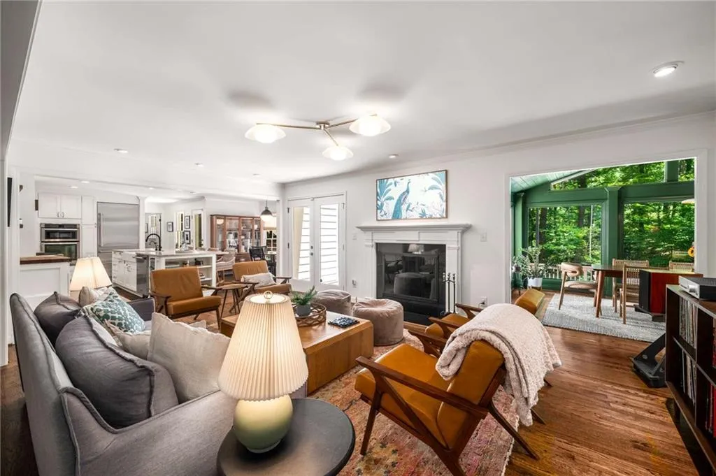 Living area featuring dark wood-style floors, crown molding, a fireplace, and recessed lighting