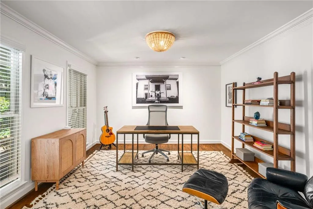 Office area with wood finished floors and crown molding