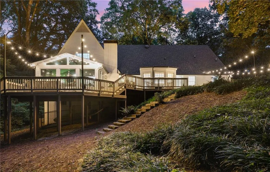 Rear view of property featuring a wooden deck, a chimney, and stairway