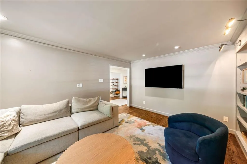 Living room with crown molding, recessed lighting, and wood finished floors