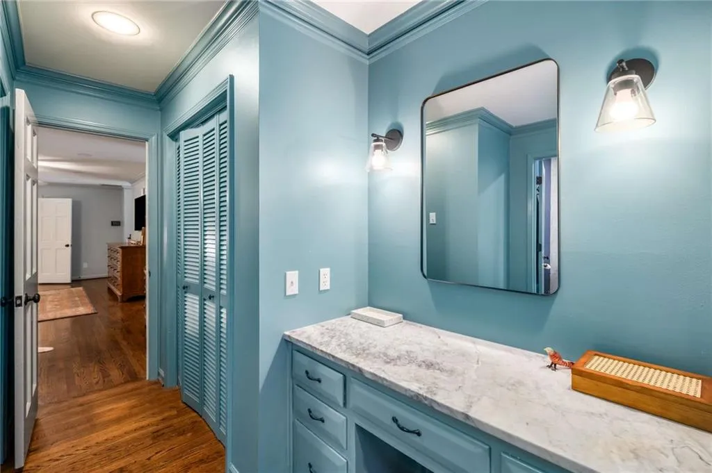 Bathroom featuring wood finished floors, crown molding, and vanity
