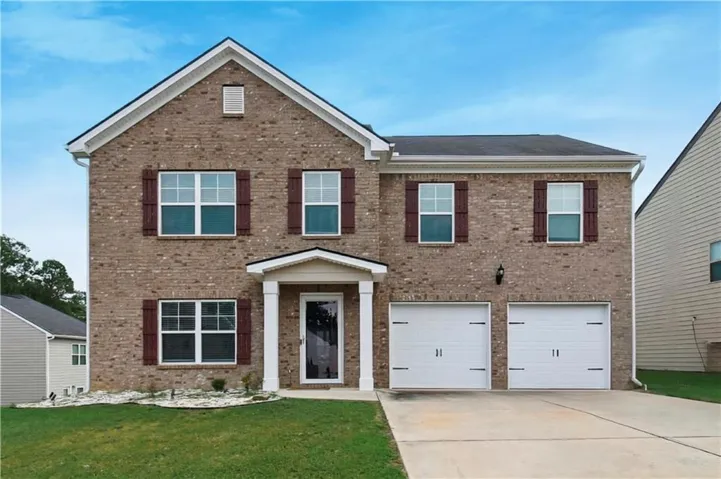 Brick exterior with white trim, a covered entry, and a two-car garage