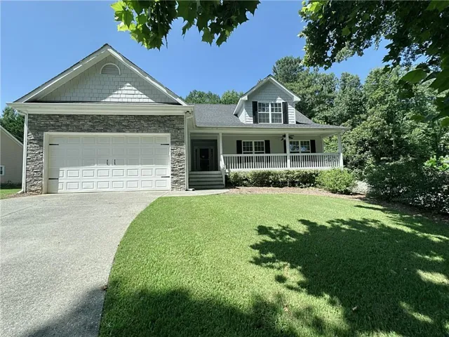 Stone veneer and shingle exterior with an attached garage