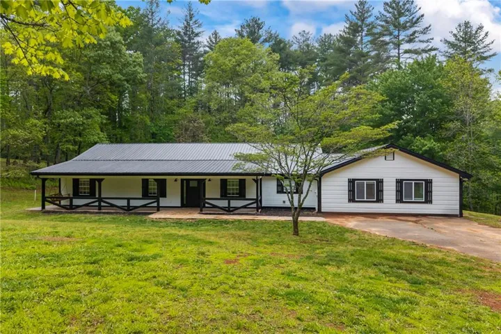 Single-story residence featuring a dark metal roof and white siding