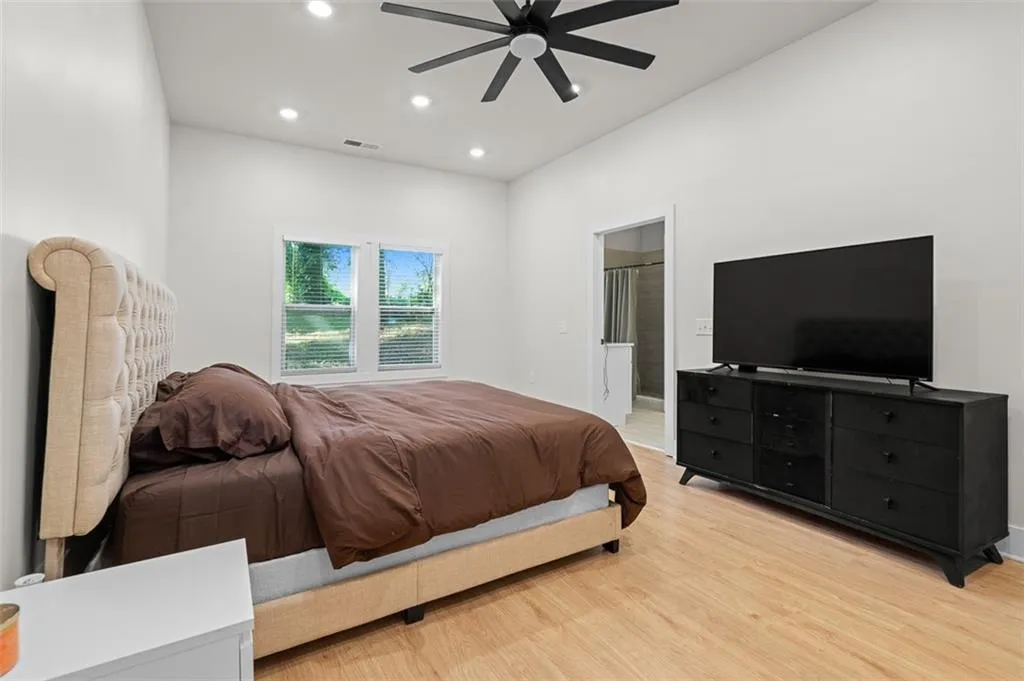Bedroom with recessed lighting, light wood-type flooring, ensuite bathroom, and a ceiling fan