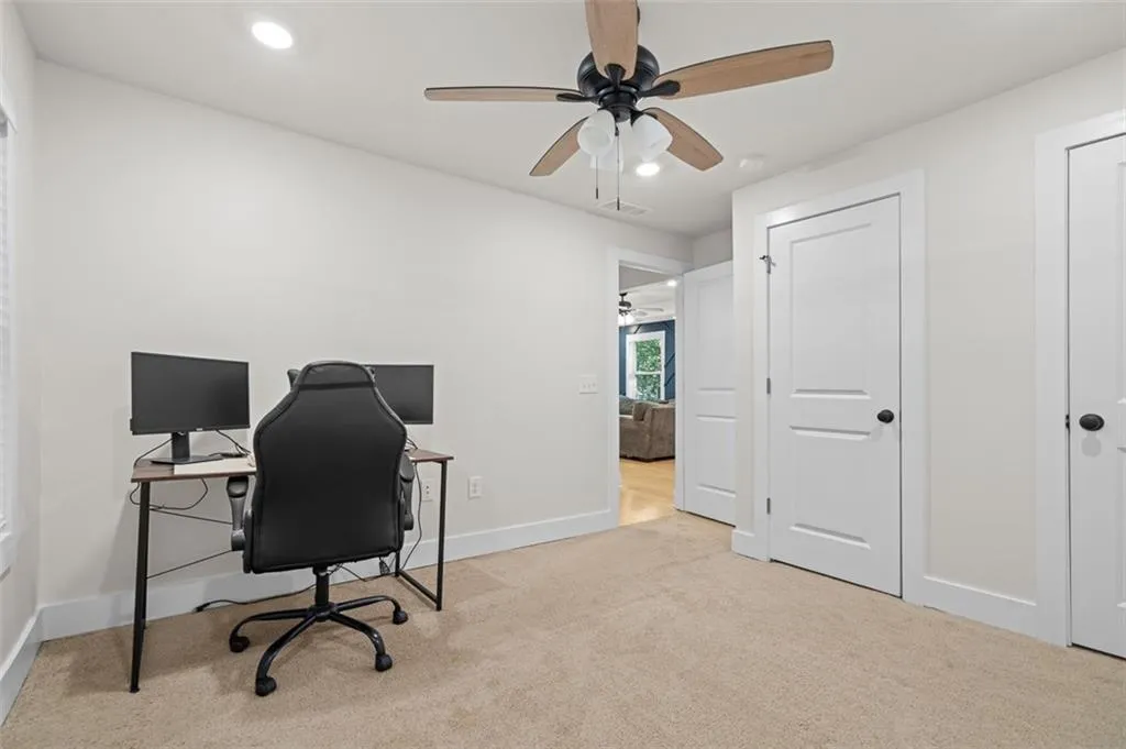 Office space with light carpet, recessed lighting, and a ceiling fan