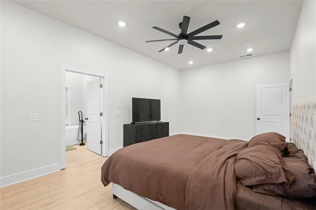 Bedroom with recessed lighting, light wood finished floors, ceiling fan, and ensuite bathroom