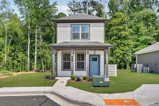 Two-story residence featuring light gray horizontal siding and dark trim