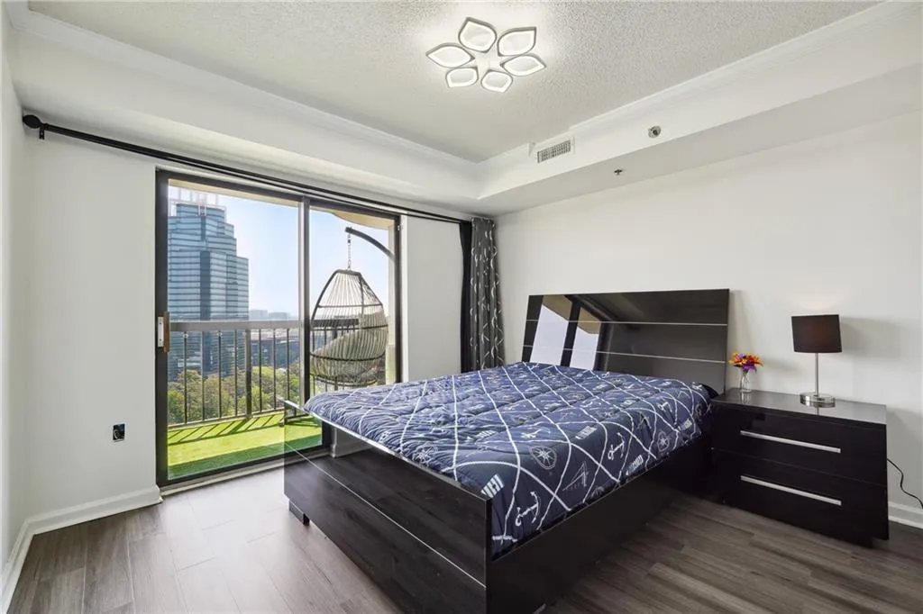 Bedroom featuring a textured ceiling, ornamental molding, dark hardwood / wood-style flooring, and multiple windows