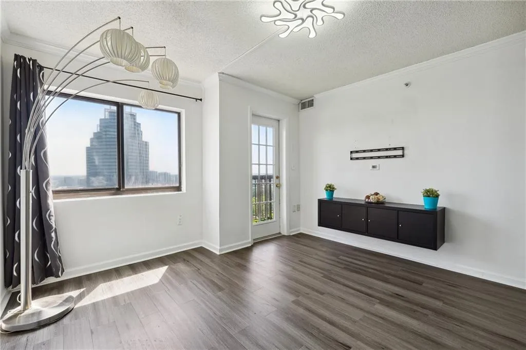 Spare room with a textured ceiling, dark wood-type flooring, and crown molding