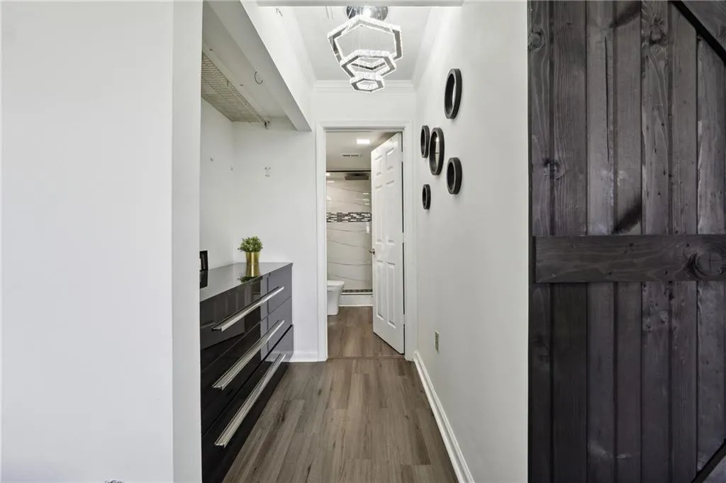 Hallway with crown molding and hardwood / wood-style flooring