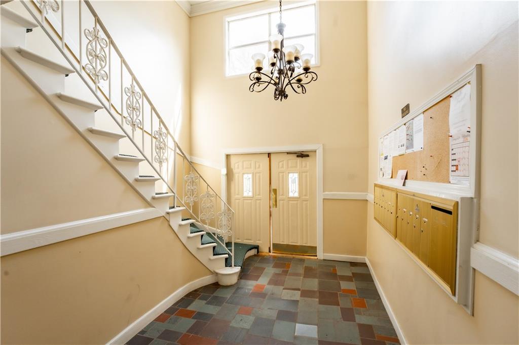 Tiled entryway featuring a chandelier and a high ceiling