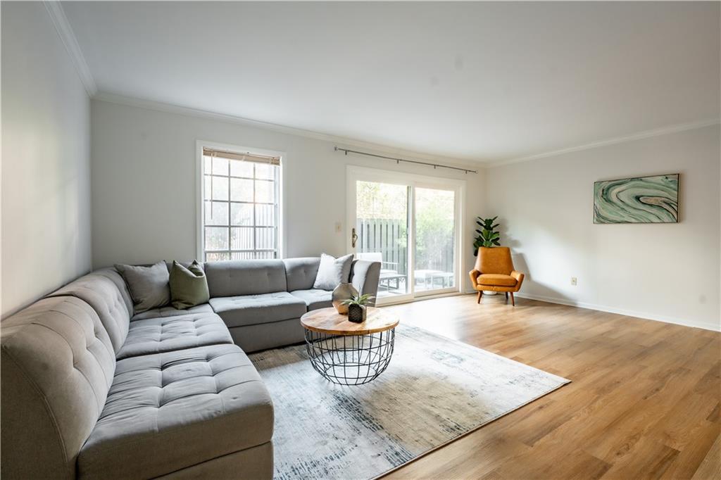 Living room featuring light wood-type flooring and ornamental molding