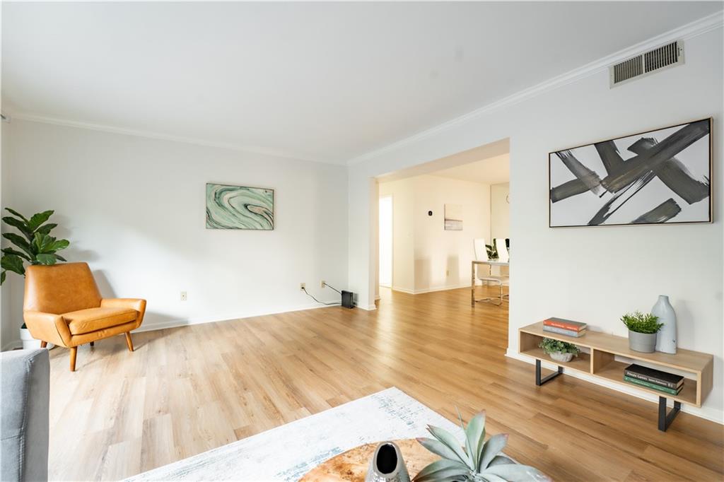 Living room with light hardwood / wood-style flooring and crown molding