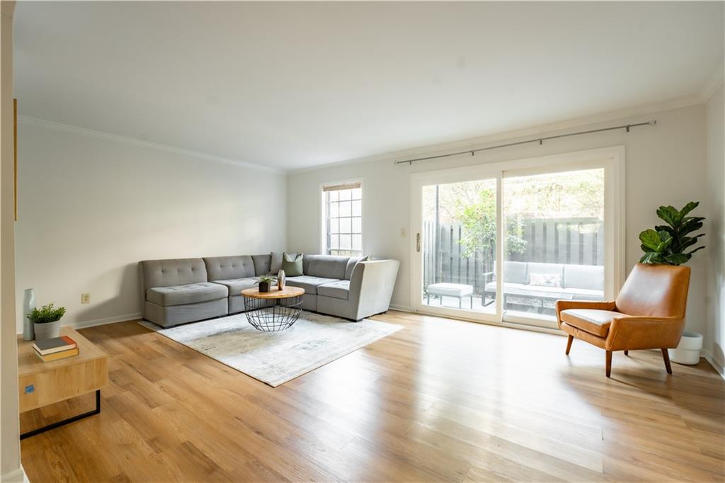 Living room with light hardwood / wood-style flooring and crown molding