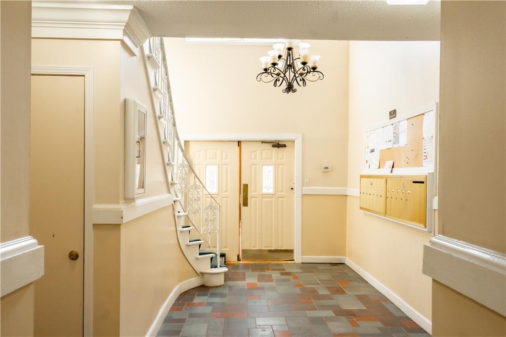 Tiled entrance foyer featuring a chandelier and a textured ceiling