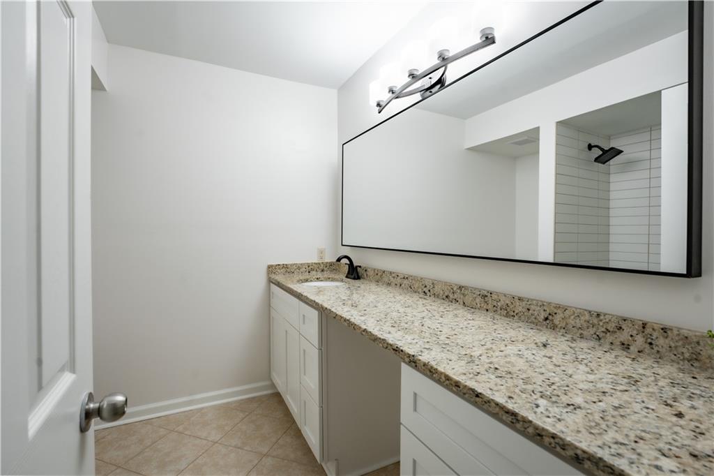 Bathroom featuring vanity with extensive cabinet space and tile flooring