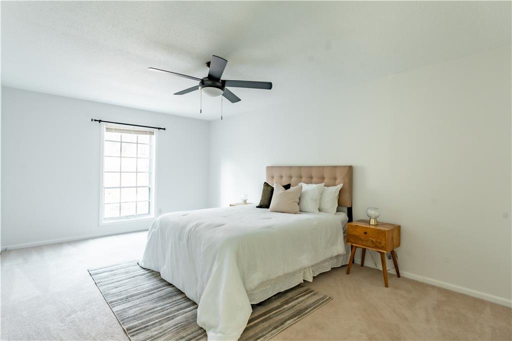 Carpeted bedroom featuring ceiling fan