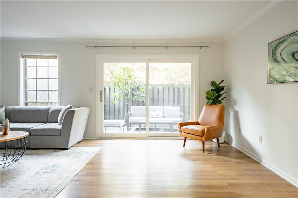 Sitting room featuring a wealth of natural light, light hardwood / wood-style flooring, and crown molding