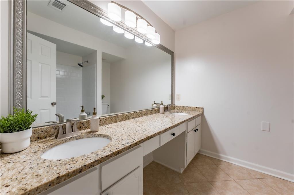 Bathroom featuring tile floors and dual vanity