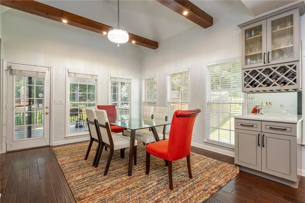 Dining area featuring beamed ceiling, bar area, and a ceiling fan