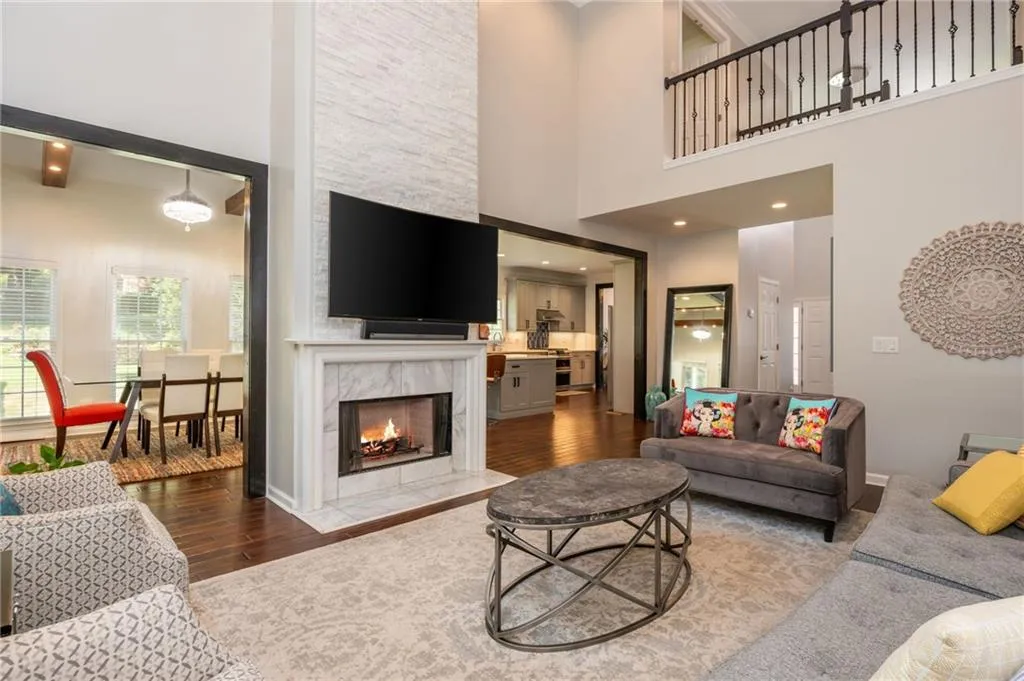 Living area with wood  floors, a towering ceiling, and a premium fireplace