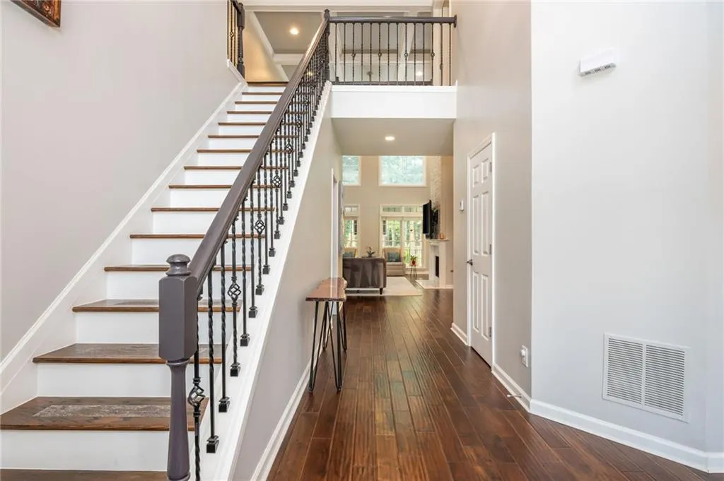 Staircase with a high ceiling and hardwood  flooring
