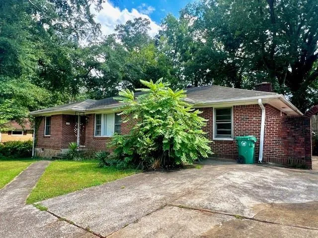 Brick exterior with a gabled roof and mature landscaping