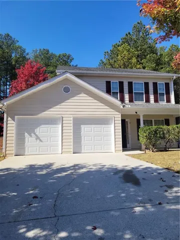 View of front of property featuring covered porch, driveway, and a garage
