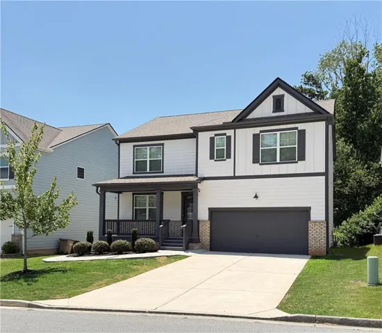 Two-story residence featuring white siding, dark trim accents, and a covered front porch
