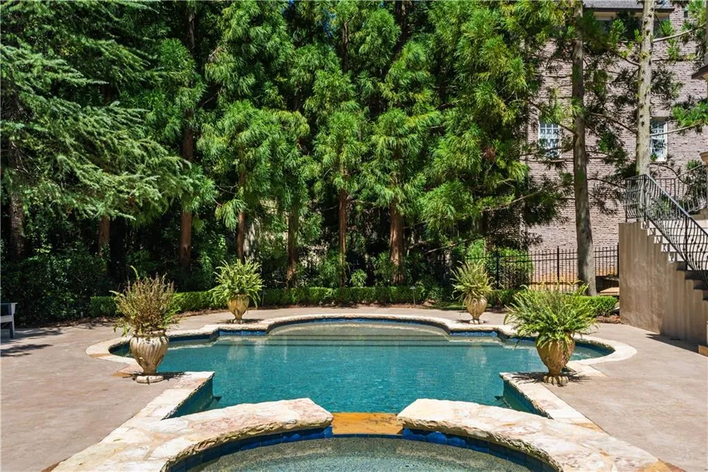View of swimming pool with a patio and an in ground hot tub