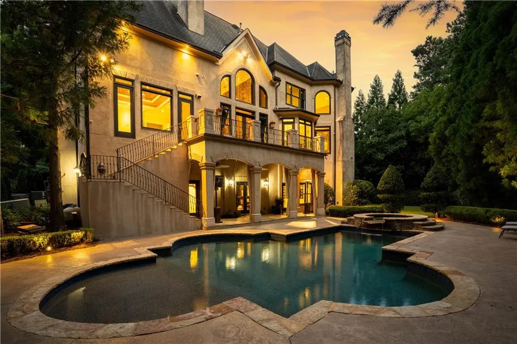 Pool at dusk featuring a patio area and an in ground hot tub